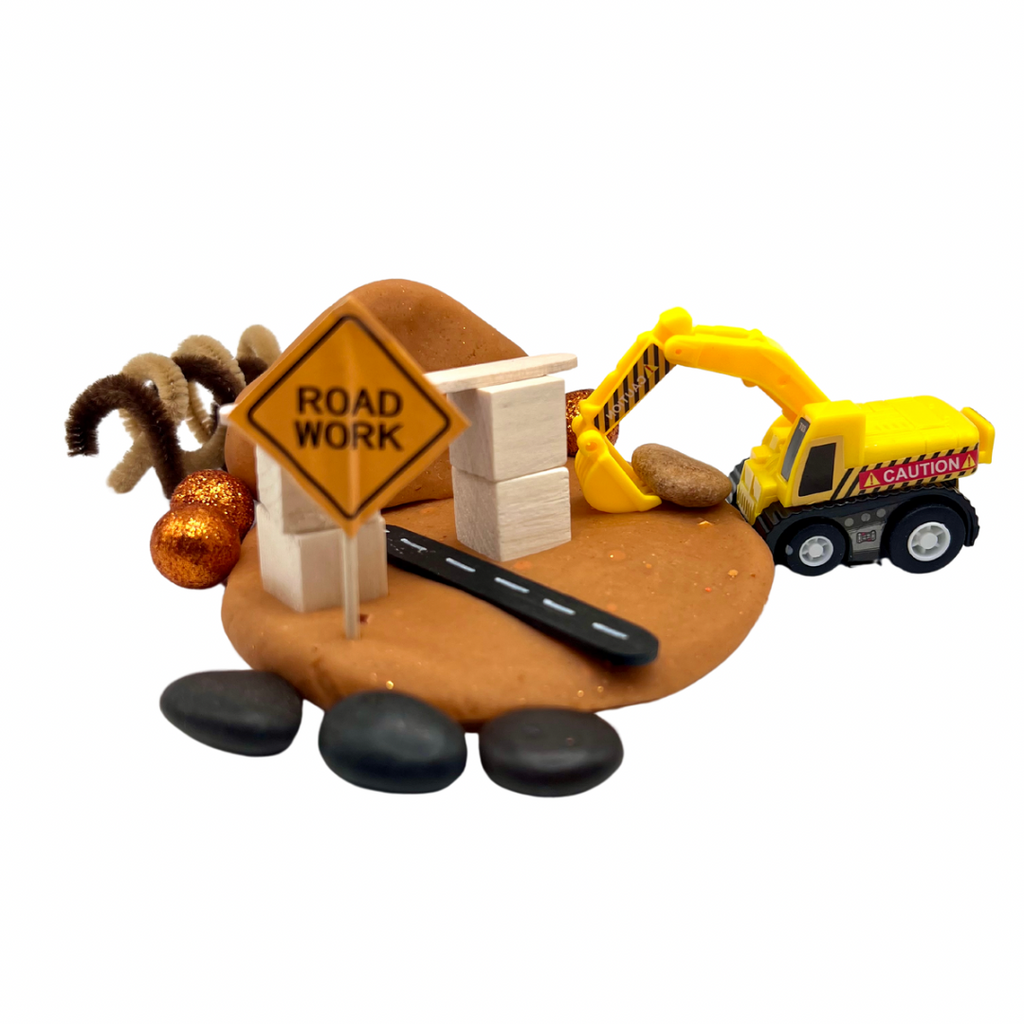 Construction Site Playdough Sensory Kit | Natural Dough with Trucks, Rocks & Gems featuring a yellow toy excavator, wooden blocks, road work sign, and textured playdough base for sensory play and fine motor skills development.