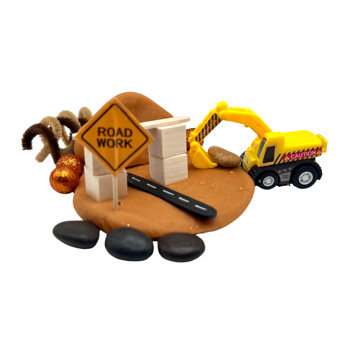 Construction Site Playdough Sensory Kit | Natural Dough with Trucks, Rocks & Gems featuring a yellow toy excavator, wooden blocks, road work sign, and textured playdough base for sensory play and fine motor skills development.