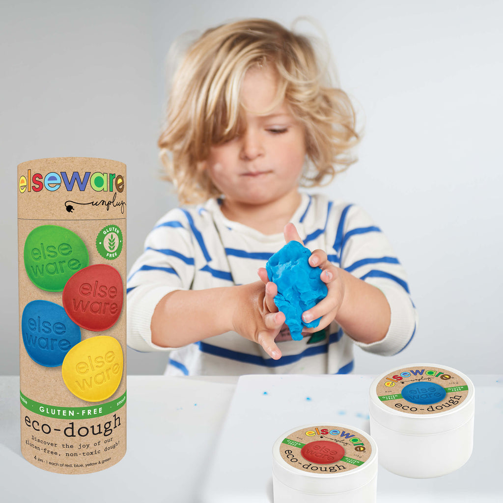 Child playing with blue Eco-Dough 4pk | Gluten-Free Natural Playdough Sensory Toy for Kids, shown with packaging and containers featuring colorful dough discs for sensory and fine motor skill development.
