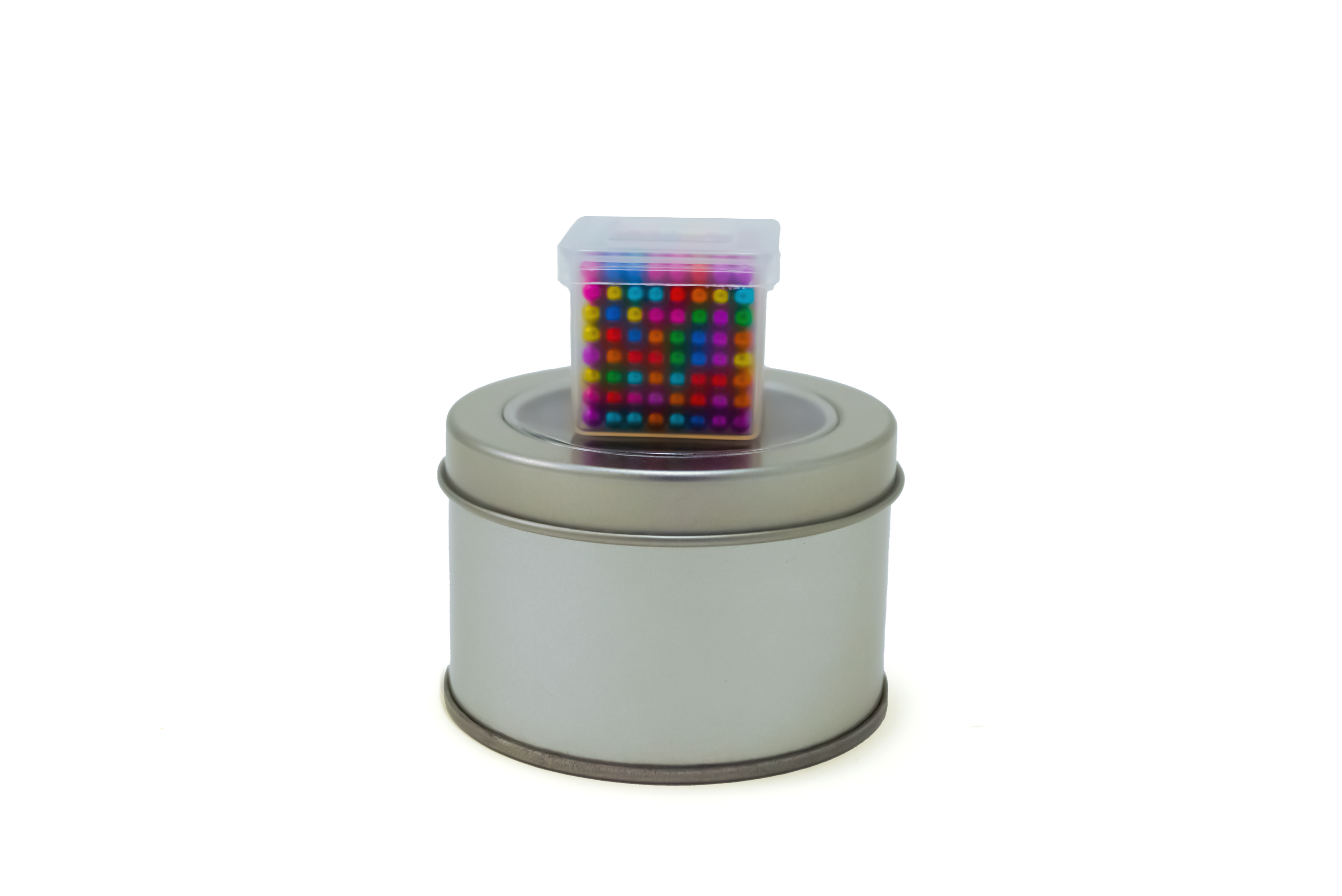 Magnetic Balls Fidget Toy | 3MM Neodymium Stress Relief Balls for Adults & Teens displayed in a clear plastic container on top of a silver metal tin, colorful and compact sensory toy.