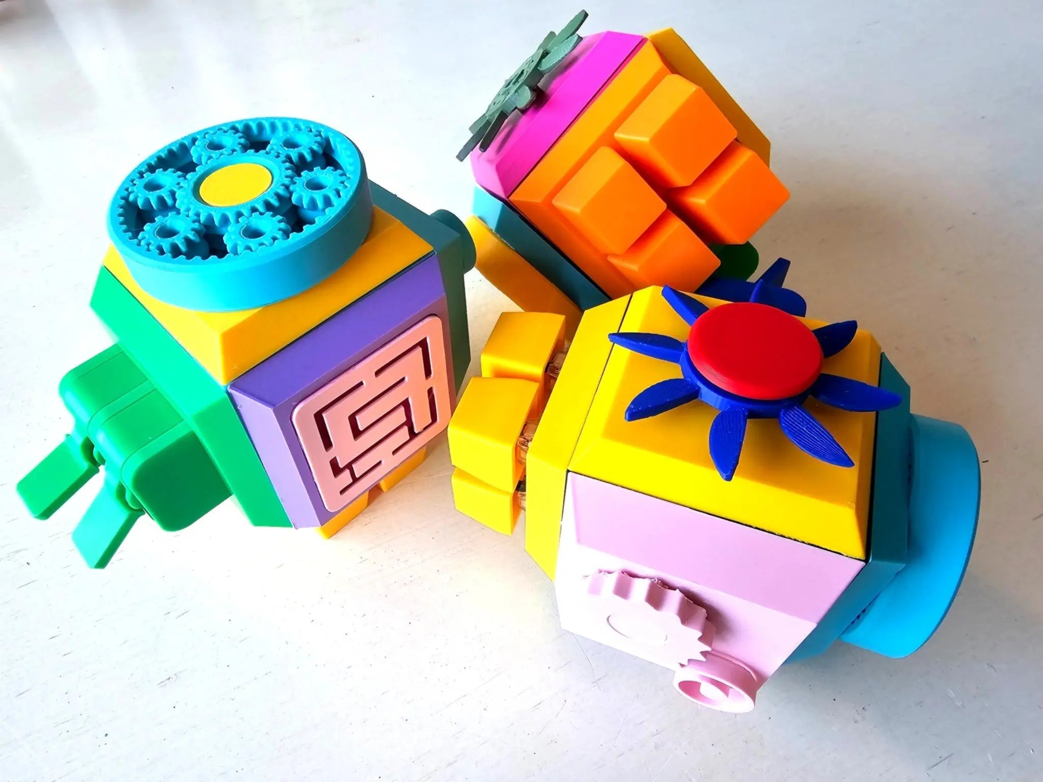 Brightly colored Modular Fidget Cube | Swappable Sensory Toy for Kids 4+ | 4 Inch showing multiple sides with textured gears, buttons, and tactile elements for sensory engagement.