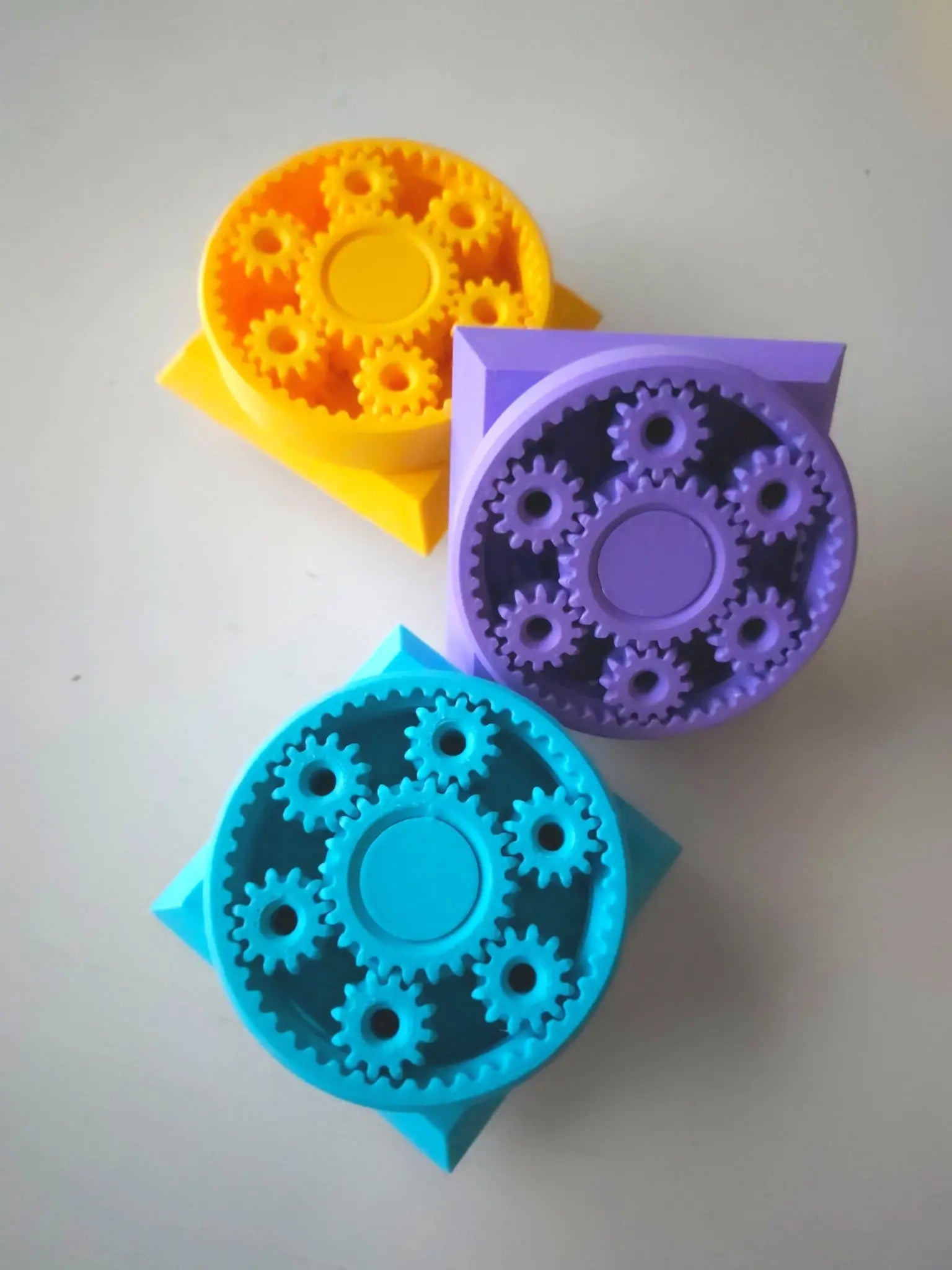 Three colorful Modular Fidget Cube | Swappable Sensory Toy for Kids 4+ | 4 Inch with interlocking gears in yellow, purple, and blue on a light background.